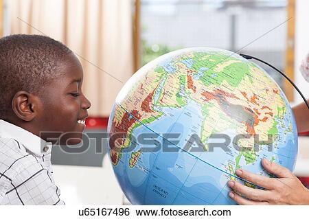 Stock Photograph - boy learning geography. Fotosearch