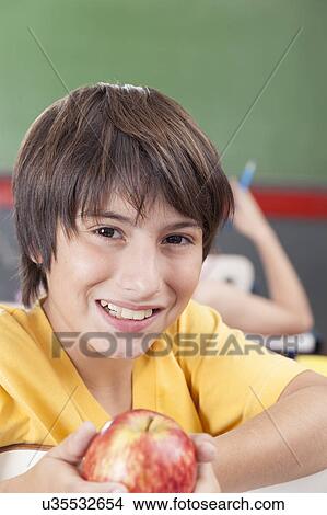 Boy showing an apple View Large Photo Image Picture - Boy showing an apple. Fotosearch