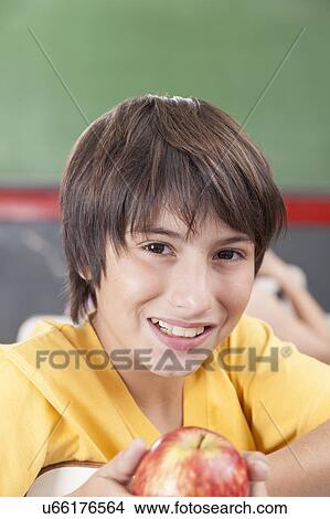 Boy showing an apple View Large Photo Image Picture - Boy showing an apple. Fotosearch