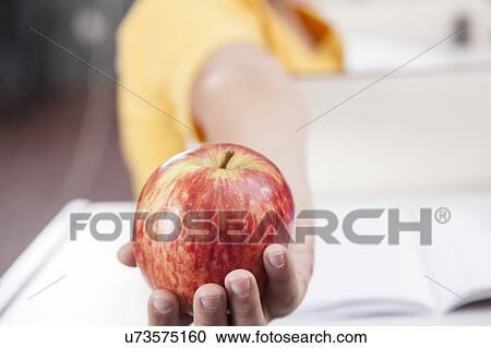 Stock Image - Boy showing an apple. Fotosearch