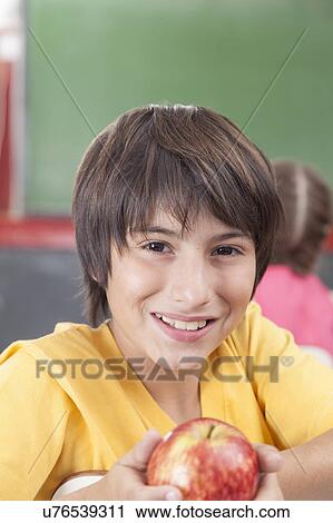 Boy showing an apple View Large Photo Image Stock Image - Boy showing an apple. Fotosearch