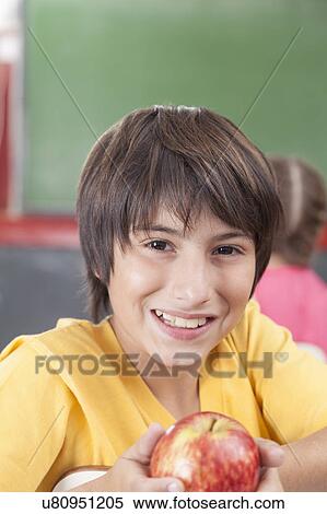 Stock Photography - Boy showing an apple. Fotosearch