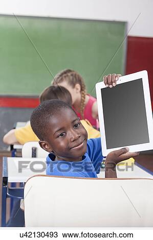 Stock Image - Boy showing the tablet. Fotosearch
