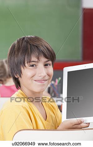 Stock Photo - Boy showing the tablet. Fotosearch