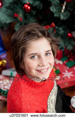 Stock Image - Boy sitting beside the christmas tree. Fotosearch