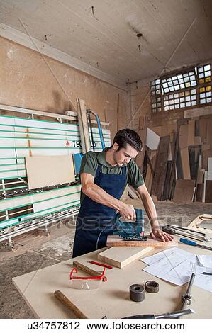 Stock Image - Carpenter cut with a machine. Fotosearch