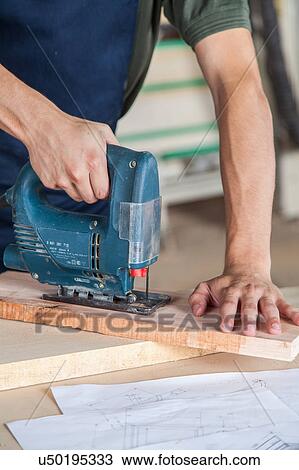 Stock Image - Carpenter cut with a machine. Fotosearch