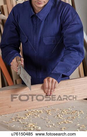 Carpenter cutting a piece ok wood View Large Photo Image Stock Photography - Carpenter cutting a piece ok wood. Fotosearch