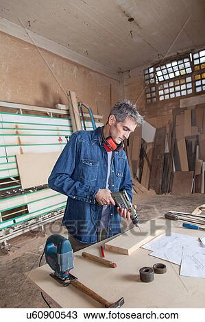 Carpenter holding a drill View Large Photo Image Stock Image - Carpenter holding a drill. Fotosearch