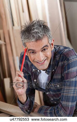 Stock Image - Carpenter holding a pencil. Fotosearch