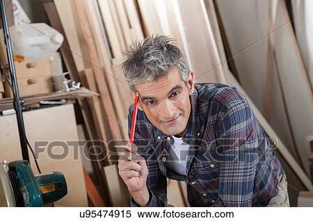 Carpenter holding a pencil View Large Photo Image Stock Photography - Carpenter holding a pencil. Fotosearch