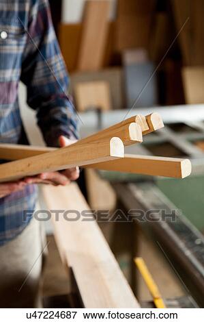 Carpenter holding a pieces of wood View Large Photo Image Stock Photo - Carpenter holding a pieces of wood. Fotosearch
