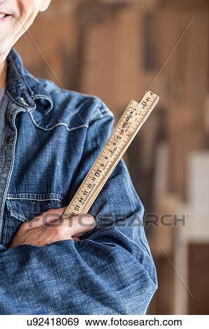 Stock Photo - Carpenter holding a ruler. Fotosearch