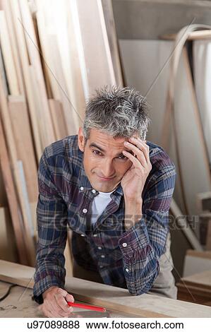 Stock Photo - Carpenter holding his head. Fotosearch