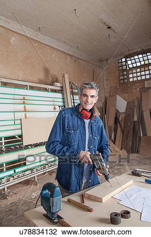 Carpenter in his desk with a drill View Large Photo Image Stock Image - Carpenter in his desk with a drill. Fotosearch