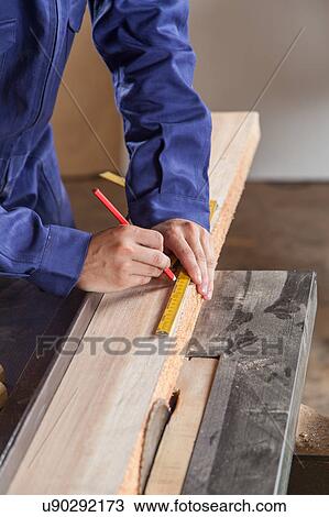 Carpenter measuring a piece of wood View Large Photo Image Stock Image - Carpenter measuring a piece of wood. Fotosearch