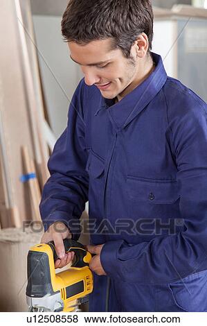 Stock Photo - Carpenter using a electric saw. Fotosearch