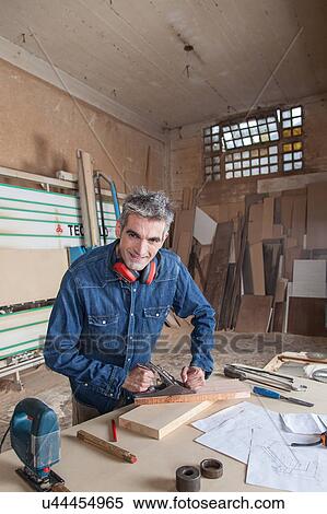 Stock Photography - Carpenter working in his desk. Fotosearch