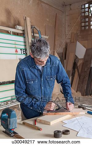 Stock Photo - Carpenter working in his workshop. Fotosearch