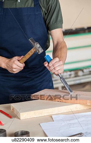 Stock Photo - Carpenter working with a chisel. Fotosearch