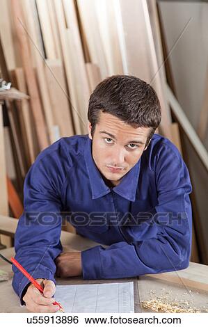 Carpenter writing in his workshop View Large Photo Image Stock Photograph - Carpenter writing in his workshop. Fotosearch