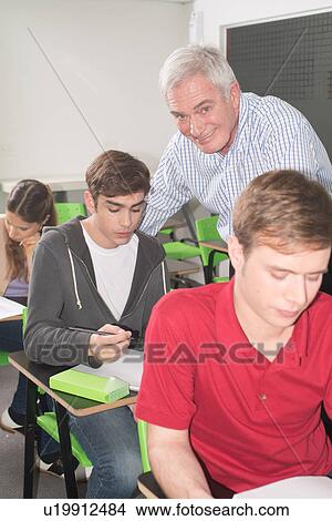 College teacher helps his students View Large Photo Image Picture - College teacher helps his students. Fotosearch