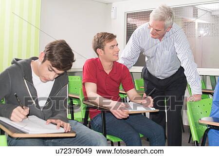 Stock Photo - College teacher helps his students. Fotosearch