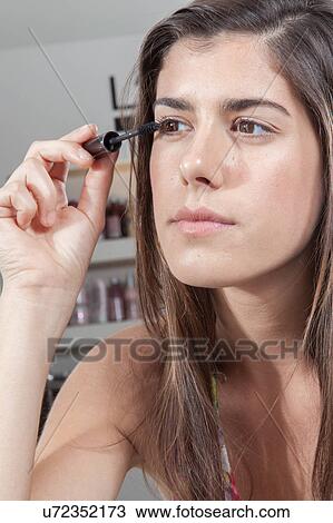 Concentrated woman applying mascara View Large Photo Image Stock Image - Concentrated woman applying mascara. Fotosearch