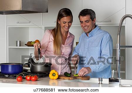 Stock Image - couple cooking in the kitchen. Fotosearch