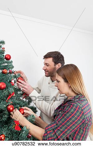 Couple decorating the christmas tree View Large Photo Image Stock Image - Couple decorating the christmas tree. Fotosearch