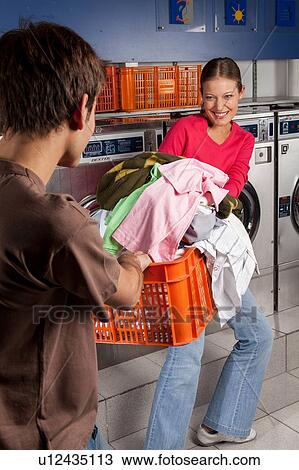 Stock Image - Couple fighting over clothes. Fotosearch