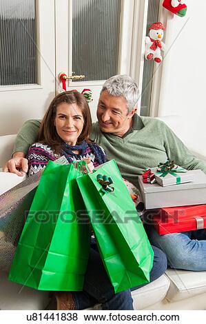 Stock Photo - Couple in the sofa with presents. Fotosearch