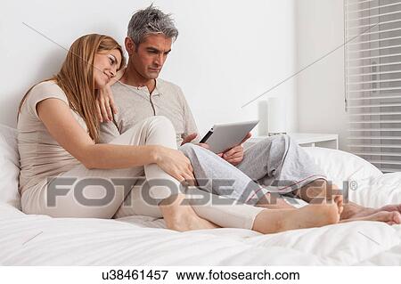 Stock Photo - Couple lying in the bed. Fotosearch