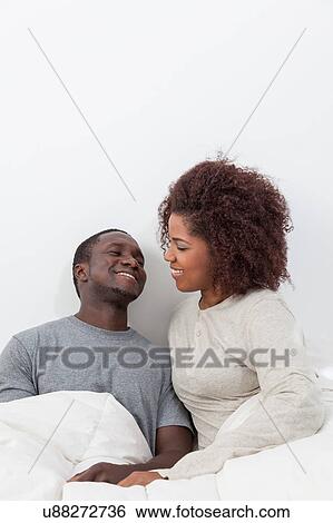 Stock Photograph - couple relaxing in bed. Fotosearch