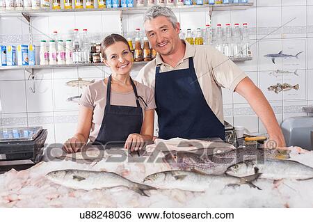 Couple selling in a fish shop View Large Photo Image Stock Photograph - Couple selling in a fish shop. Fotosearch