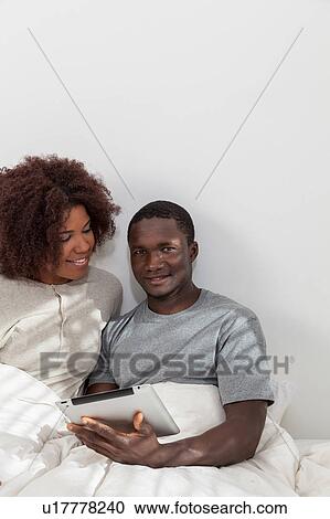 Stock Image - Couple using the ipad. Fotosearch