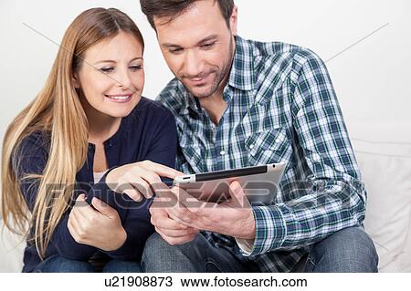 Stock Image - couple using the ipad. Fotosearch