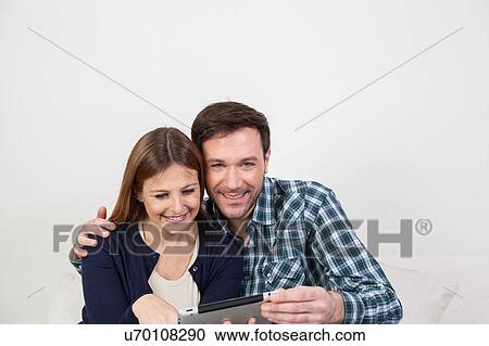 Stock Image - couple using the ipad. Fotosearch