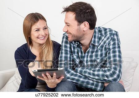 Stock Image - Couple using the ipad. Fotosearch