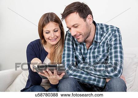 Stock Photo - Couple using the ipad. Fotosearch