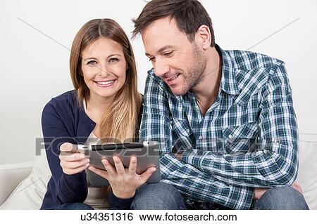 Couple using the ipad View Large Photo Image Stock Photograph - Couple using the ipad. Fotosearch