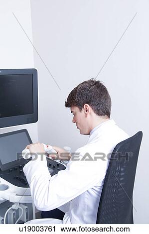 Stock Image - Doctor doing a doppler sonography. Fotosearch
