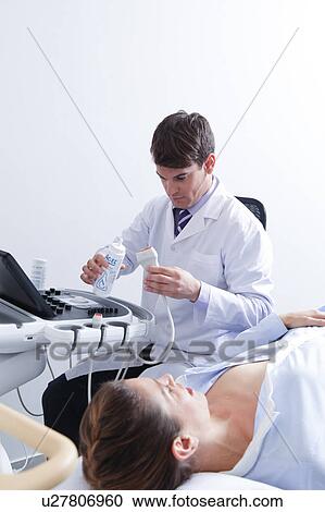 Stock Image - Doctor doing a doppler sonography. Fotosearch