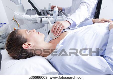 Stock Image - Doctor doing a doppler sonography. Fotosearch