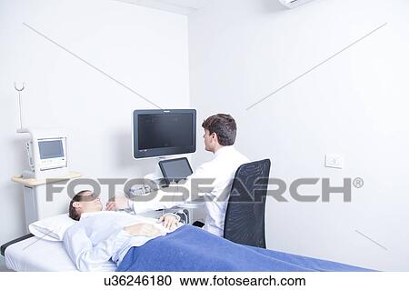 Stock Image - Doctor doing a doppler sonography. Fotosearch