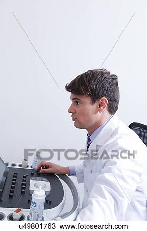 Stock Image - Doctor doing a doppler sonography. Fotosearch