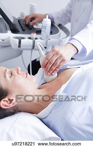 Stock Image - Doctor doing a doppler sonography. Fotosearch