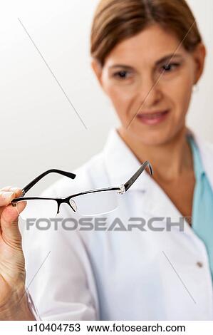 Stock Image - Doctor looking at glasses. Fotosearch