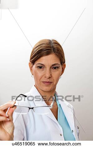 Stock Photography - Doctor looking at glasses. Fotosearch