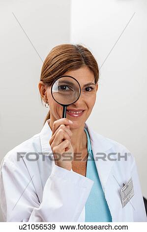 Doctor looking through magnifying glass View Large Photo Image Stock Photo - Doctor looking through magnifying glass. Fotosearch